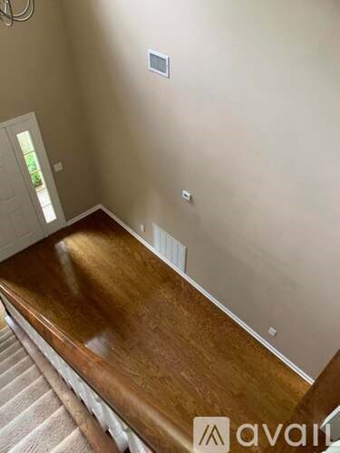 A wooden table is in the middle of a room with a white door in the background.