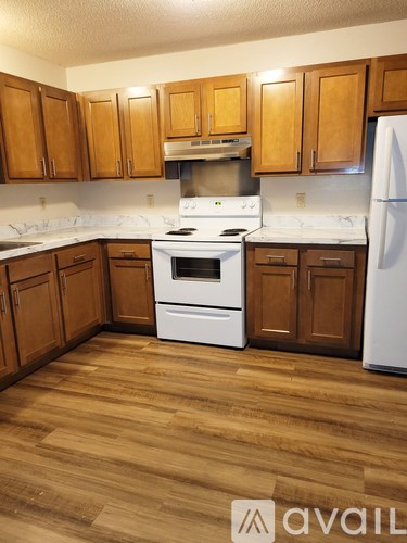 A kitchen with wooden cabinets and a white refrigerator.