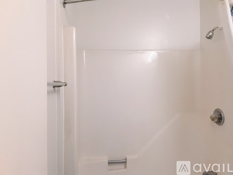 A white shower stall with a door and a shower head.