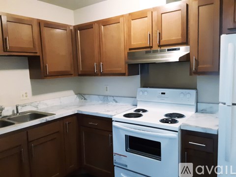 A kitchen with brown cabinets and white appliances.
