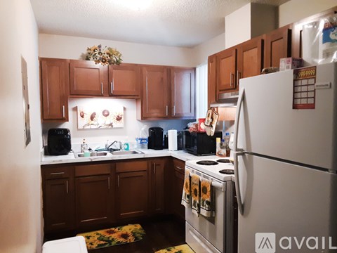 A kitchen with brown cabinets and a white refrigerator.