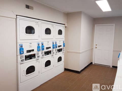 A row of white washing machines are lined up in a room.
