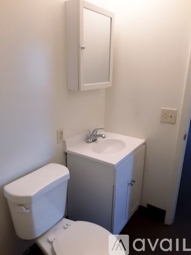 A white toilet and sink in a small bathroom.