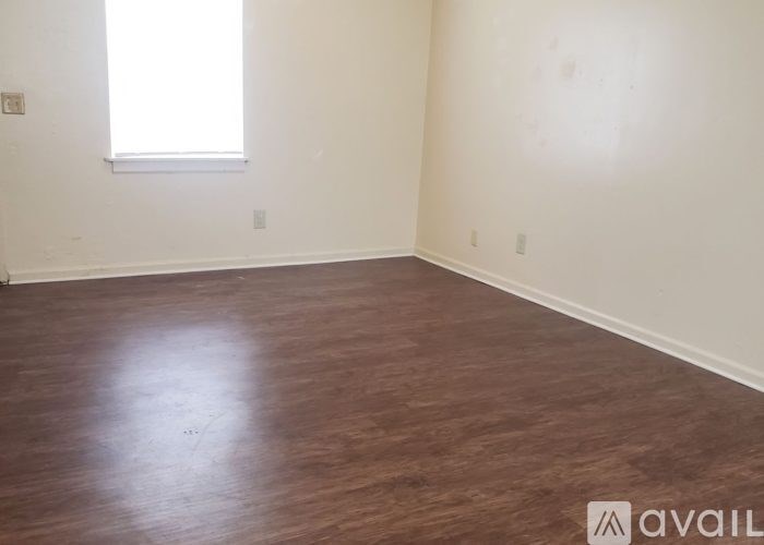 A room with wooden flooring and a window.