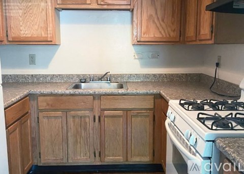 A kitchen with wooden cabinets and a granite countertop.