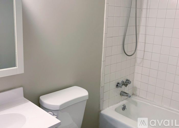 A white toilet sits next to a white sink in a bathroom.