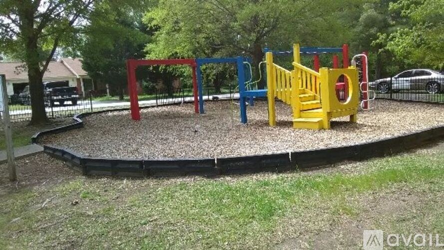 A playground with a red, blue, and yellow swing set.