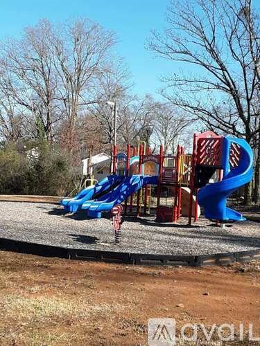 A playground with a blue slide and red and yellow structures.