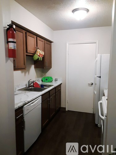 A kitchen with brown cabinets and a white fridge.