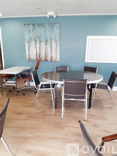A dining room with a round table and chairs.