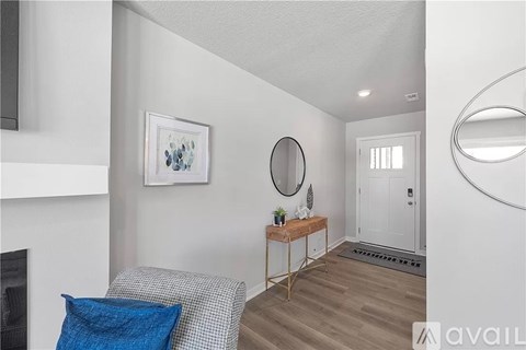 A living room with a grey couch and a blue pillow.