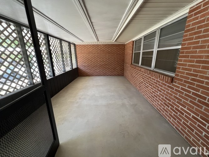 A balcony with a black railing and a brick wall.