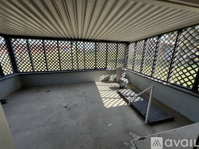 A balcony with a metal railing and a concrete floor.