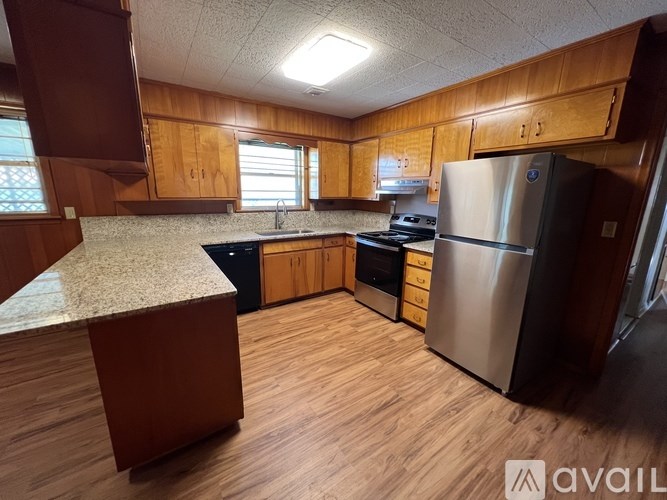 A kitchen with wooden cabinets and a granite countertop.