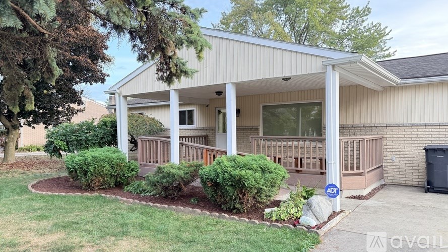 A house with a covered patio and a landscaped yard.