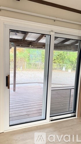 A sliding glass door with a handle and a view of a deck outside.