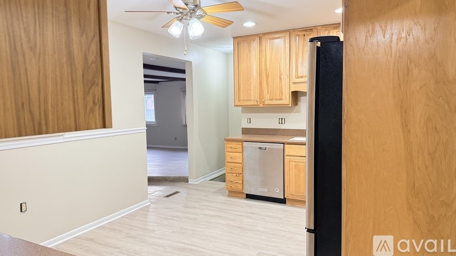 A kitchen with wooden cabinets and a black refrigerator.