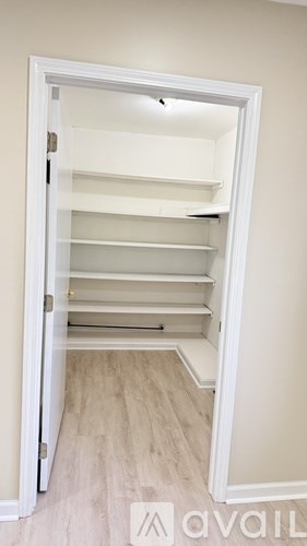 A white closet with shelves and a door open.
