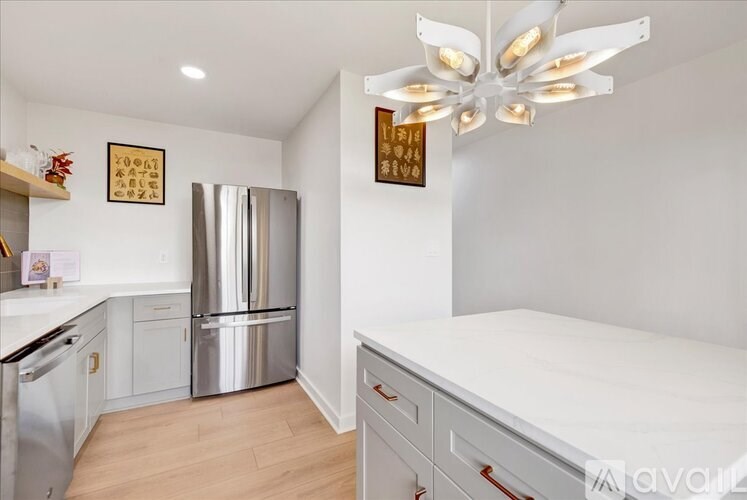 A kitchen with a stainless steel refrigerator and a white ceiling fan.