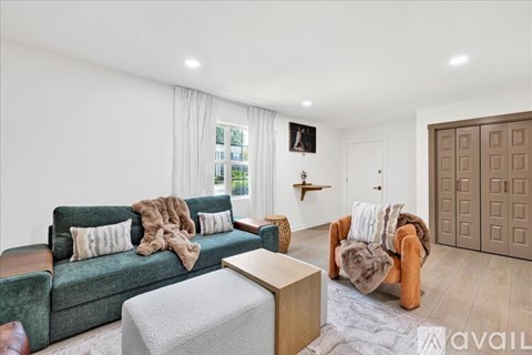 A living room with a green couch and a brown armchair.