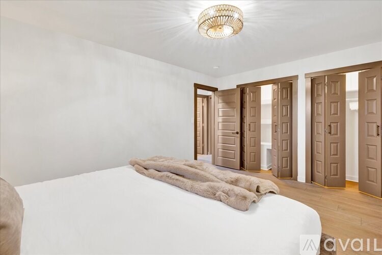A bedroom with a large bed and a chandelier.