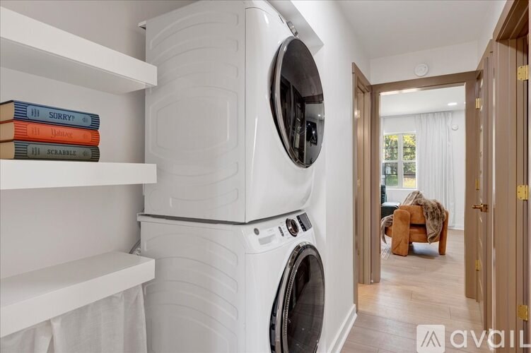 A stack of books with the top one labeled "SURRY" sits on a shelf next to a washing machine.