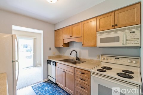 A kitchen with wooden cabinets and a white stove top oven.