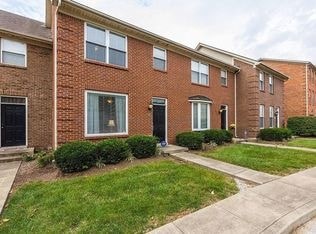 A row of red brick houses with green lawns in front.