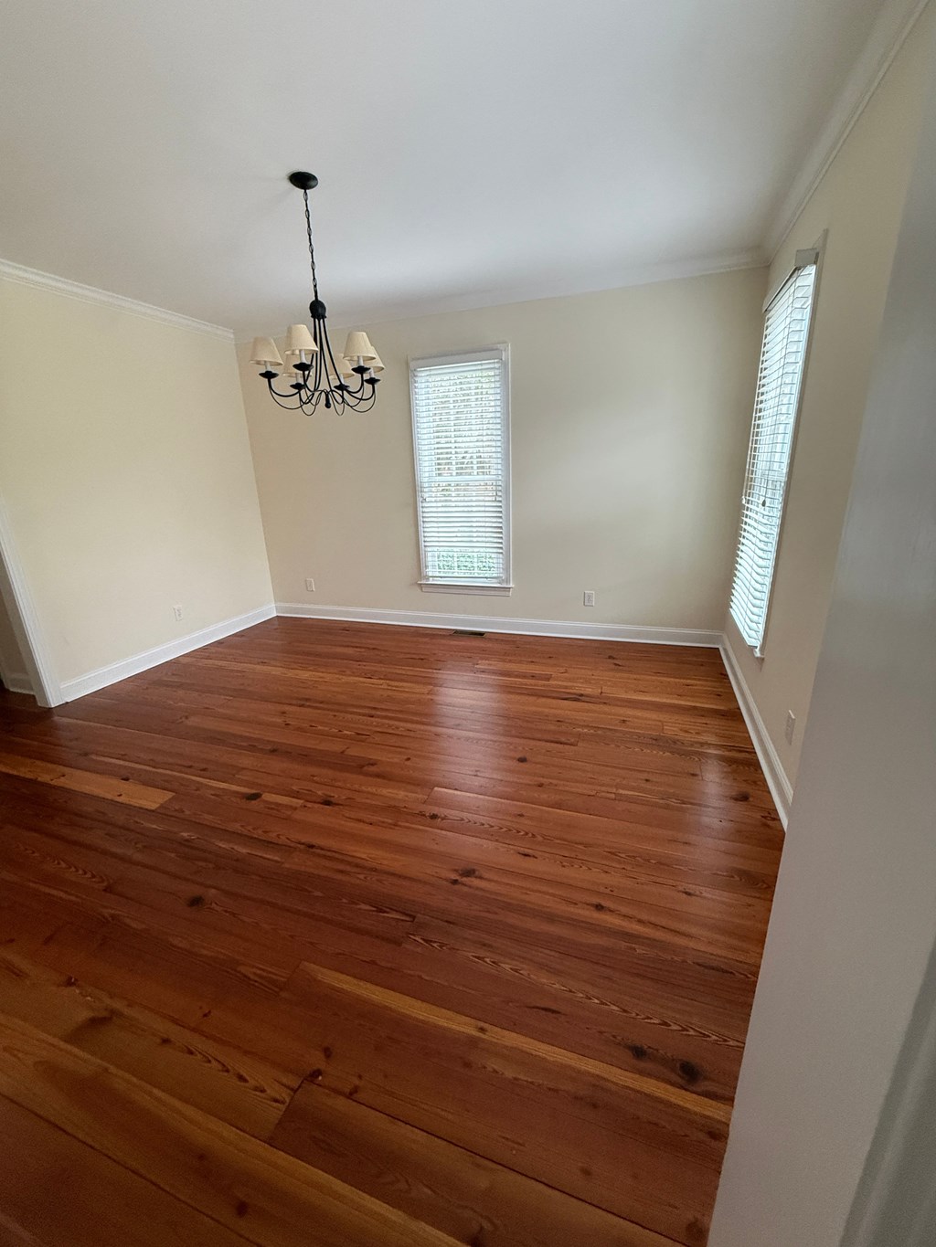 A room with wooden floors and a chandelier.