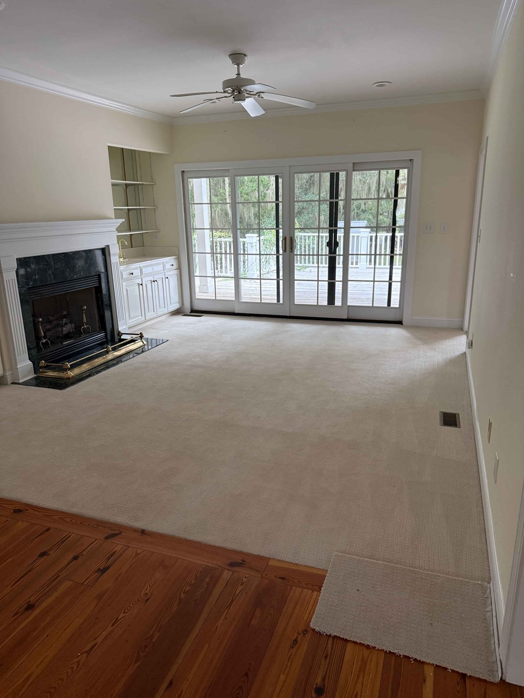 A room with a fireplace and sliding glass doors.