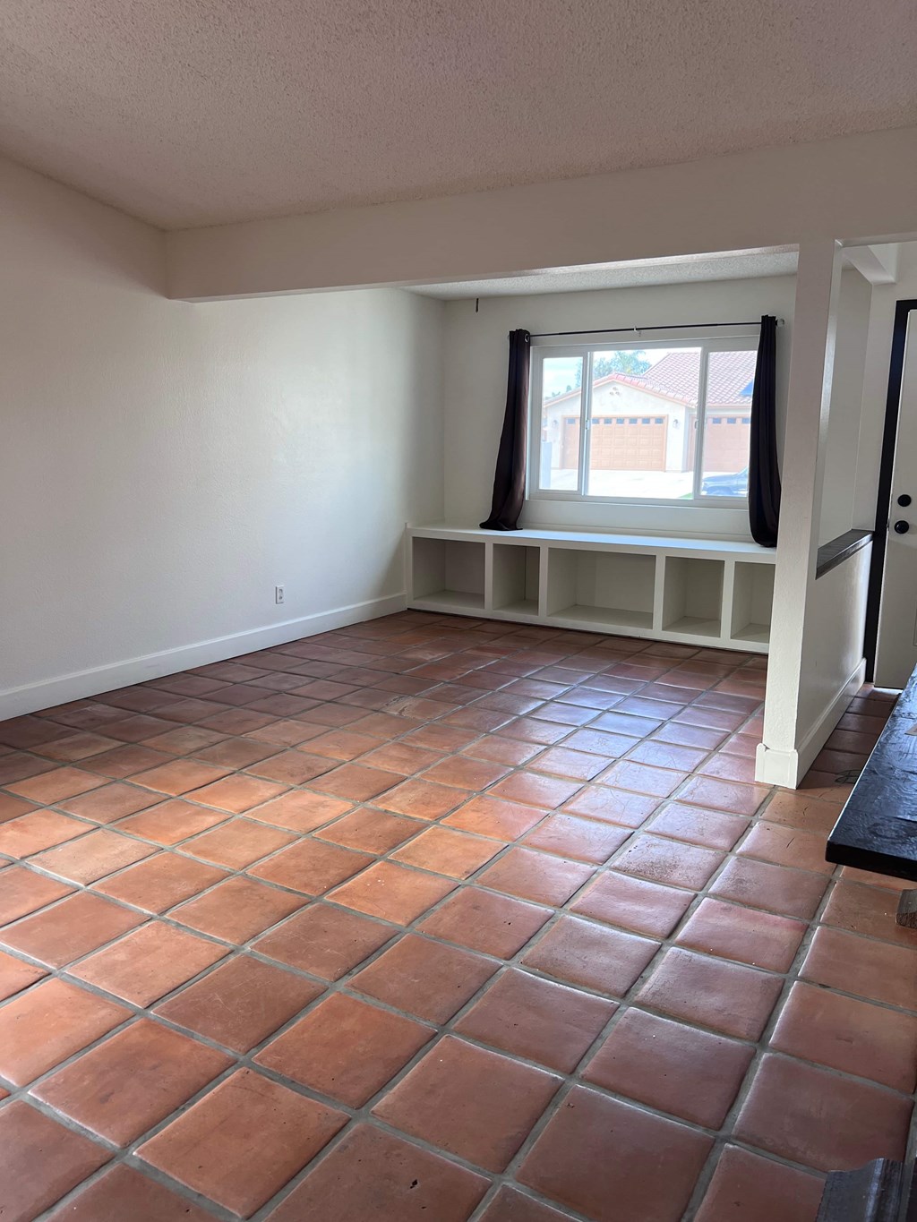 A room with a window and a tile floor.