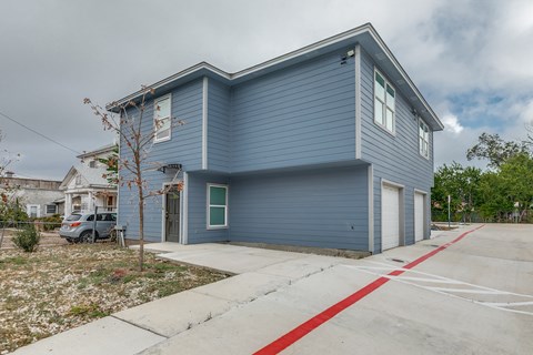 A blue house with a grey car parked in front.