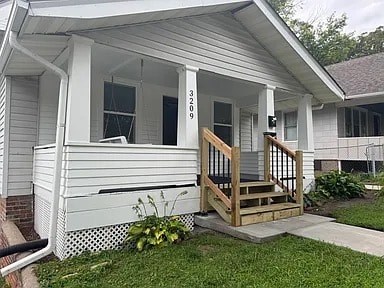 A white house with a porch and a wooden railing.