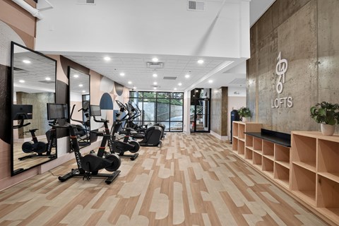 A gym with a variety of exercise equipment and wooden flooring.
