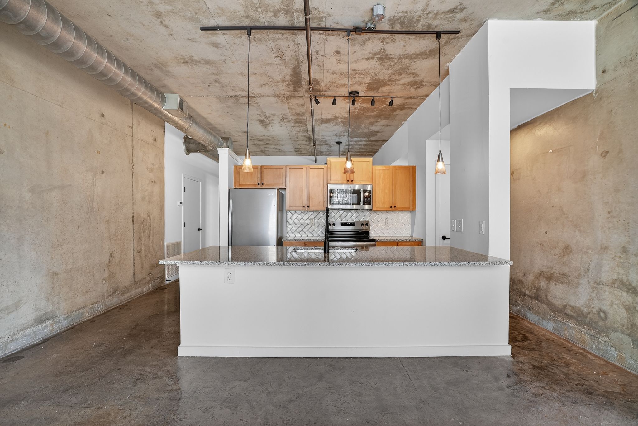 A kitchen with a white counter and two bar stools.