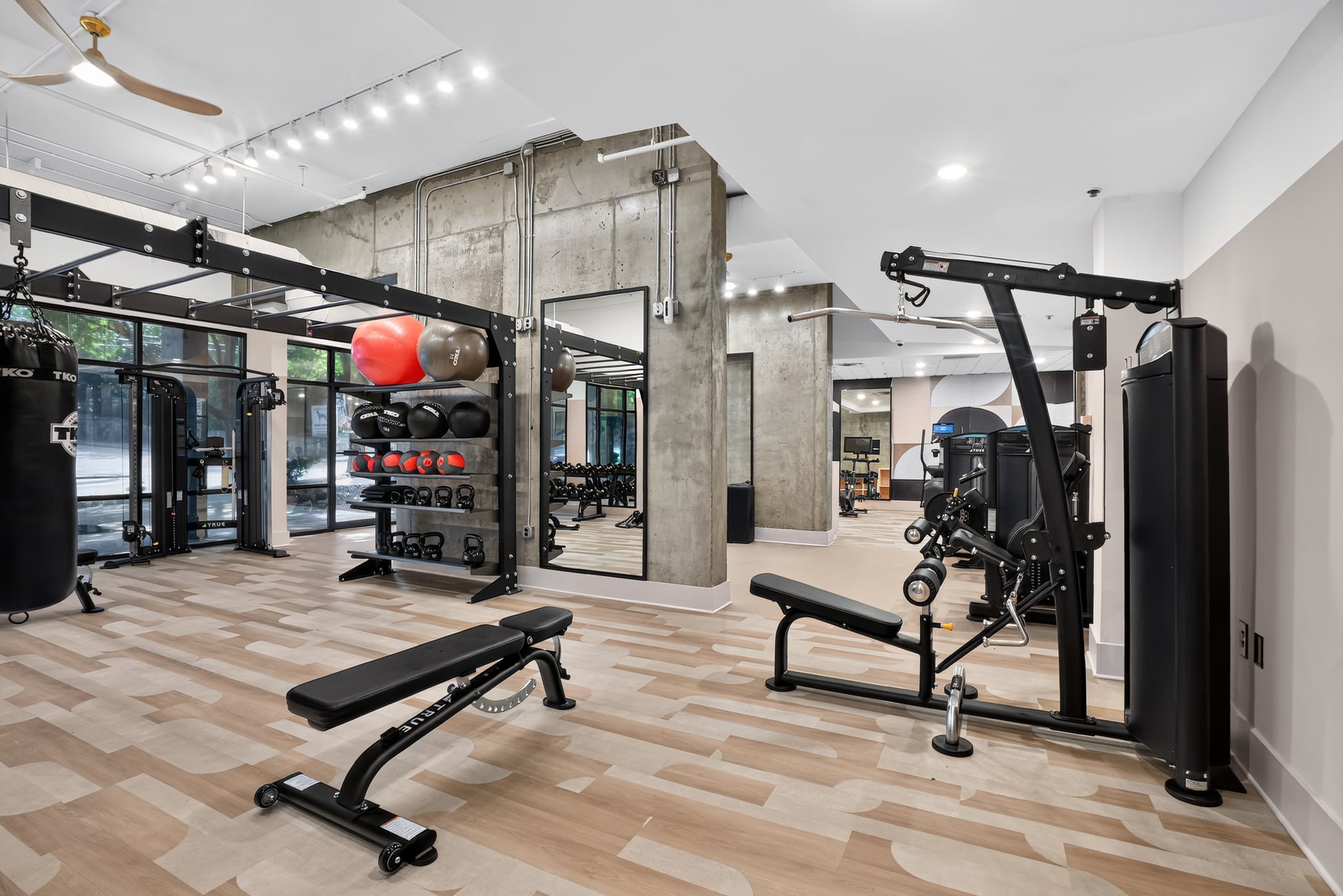 A gym with a variety of equipment including a squat rack, bench press, and a weight rack.