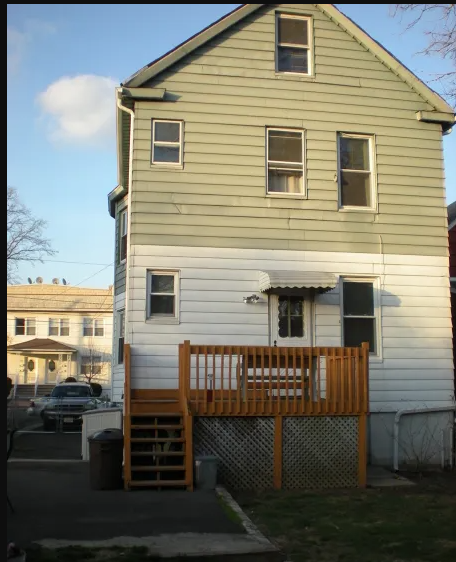 A two-story house with a white front and a green back.