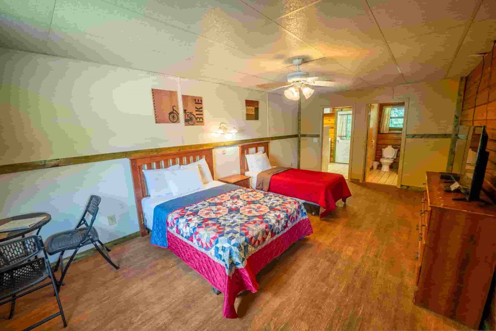 A room with two beds and a chair.