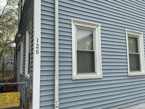 A blue house with a sign that says "Please keep out at all times. Thank you."
