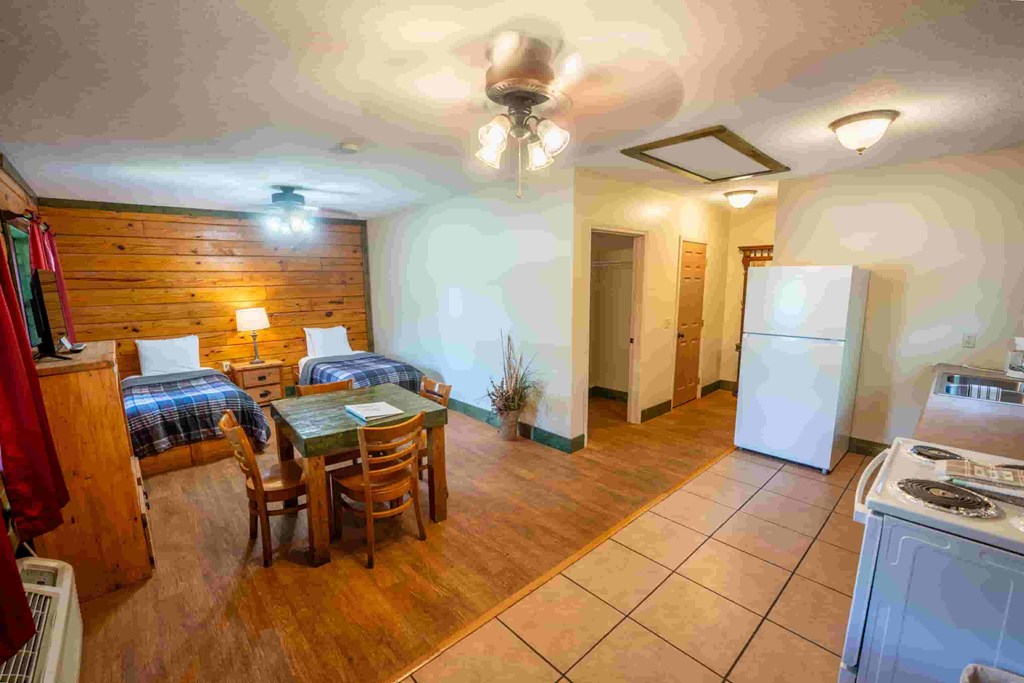 A kitchen with a dining table and chairs is visible.
