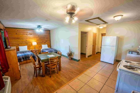 A kitchen with a dining table and chairs is visible.