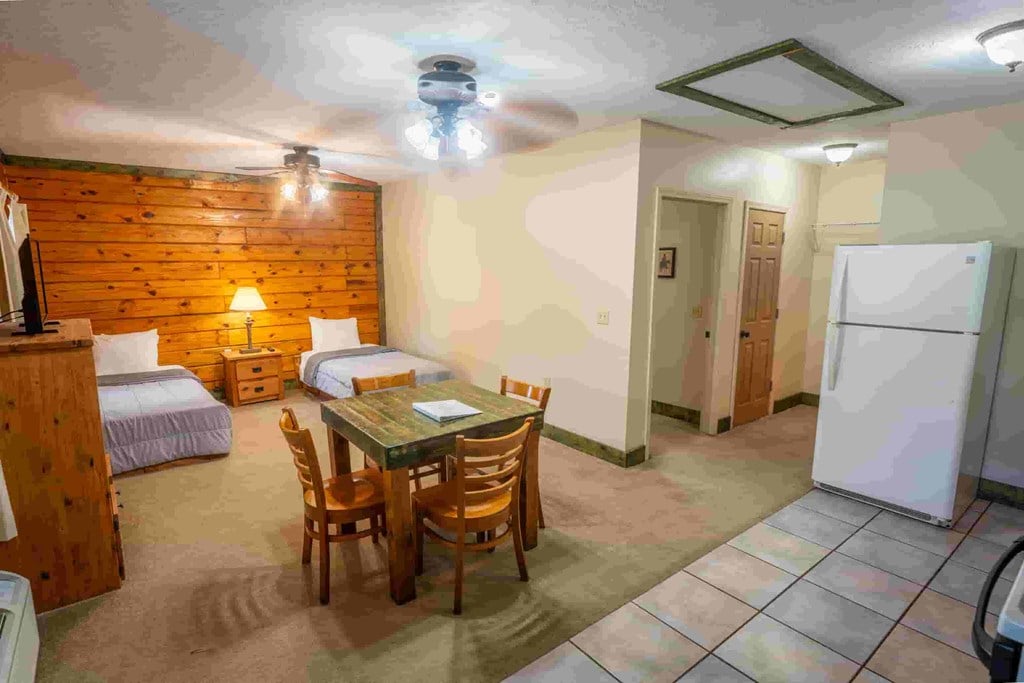 A room with a wooden wall and a table with chairs.