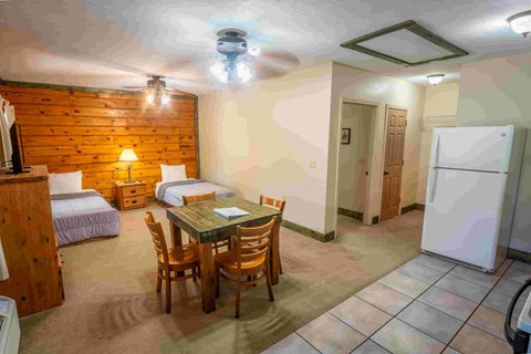 A room with a wooden wall and a table with chairs.