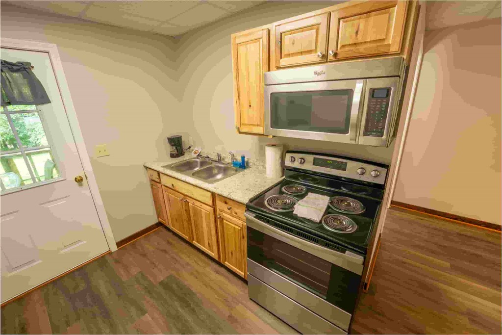 A kitchen with a stove top oven and microwave above it.