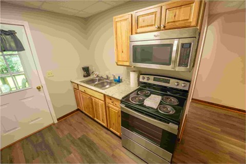 A kitchen with a stove top oven and microwave above it.
