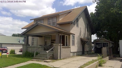 A house with a brown roof and a grey wall.