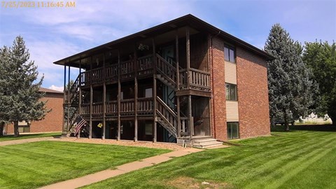 A large brick building with a balcony and a flag on it.