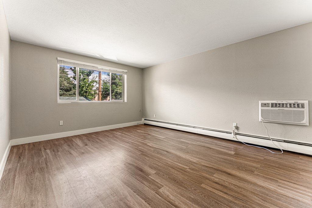 A room with a window and a wall-mounted air conditioner unit.