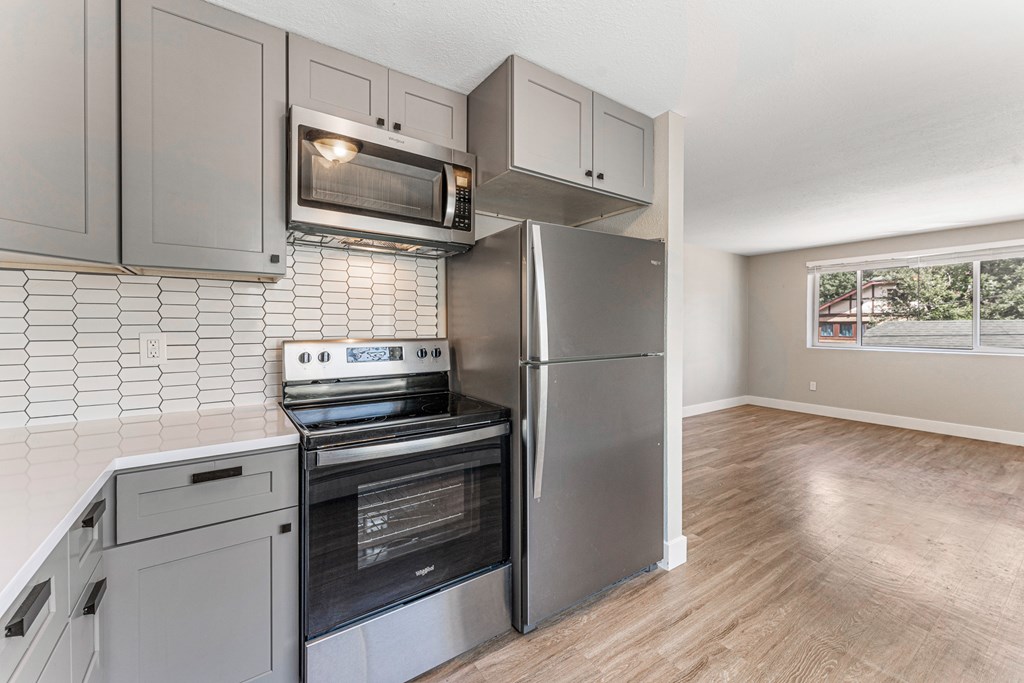 A kitchen with a stove, oven, and microwave.