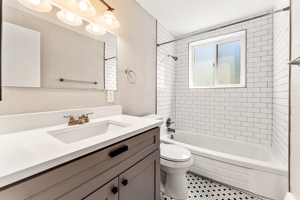 A white bathroom with a sink, toilet, and tub.